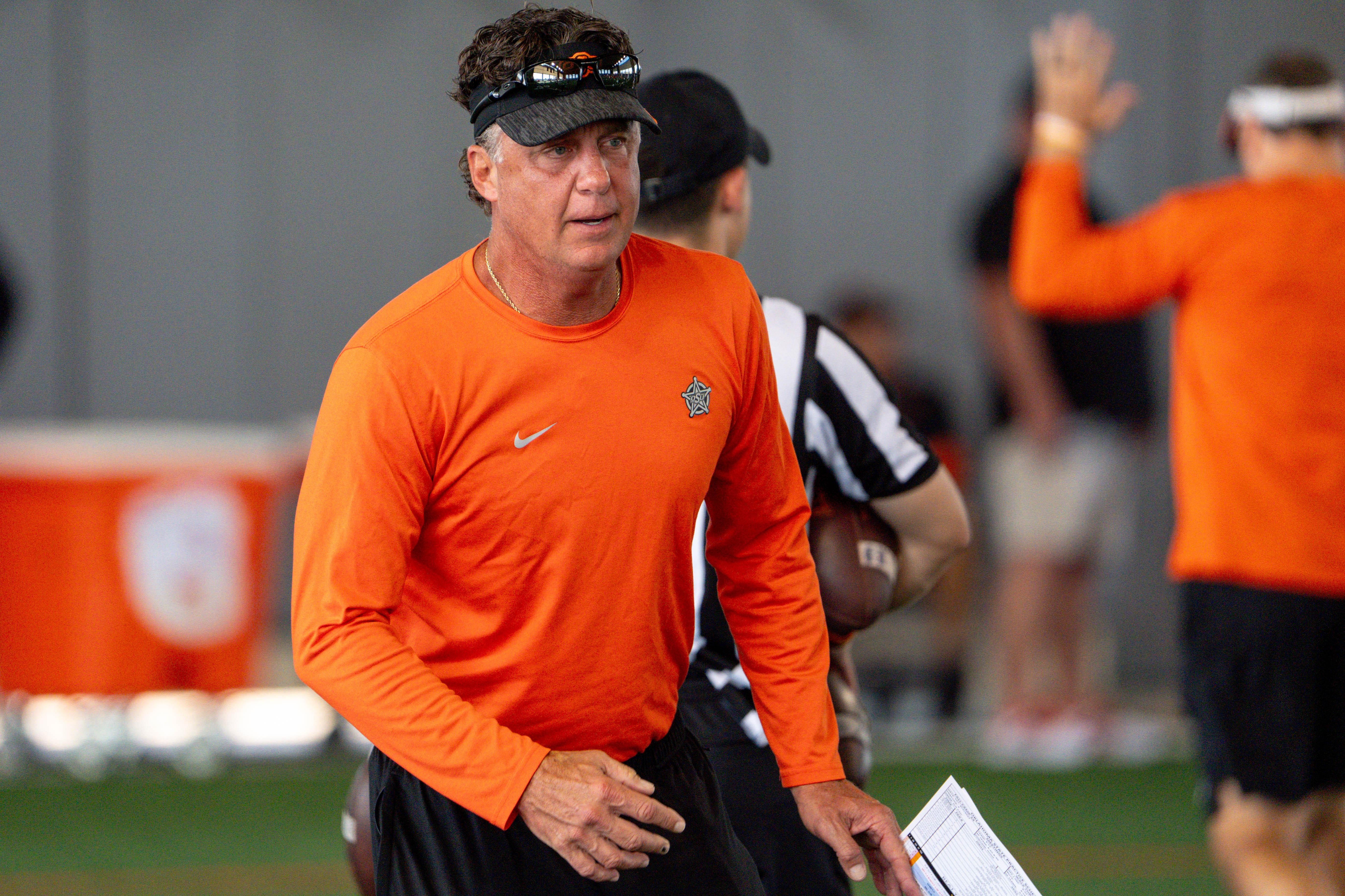 Head coach Mike Gundy walks on the field during an Oklahoma State football practice - Source: Imagn